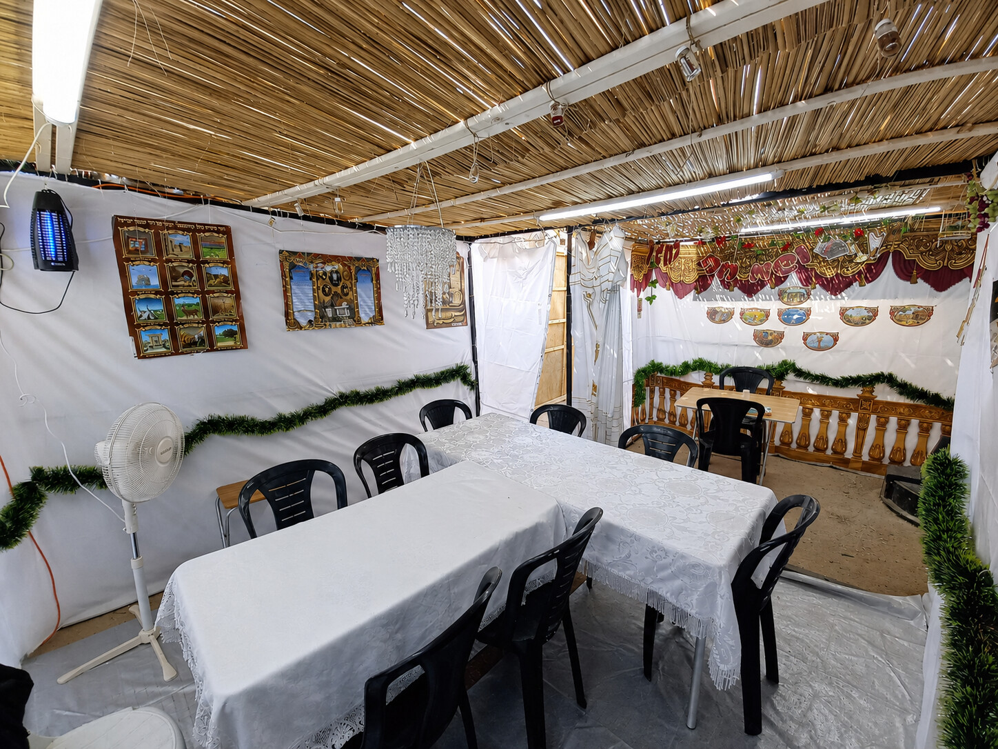 A sukkah prepared with tables and seating before Yom Tov