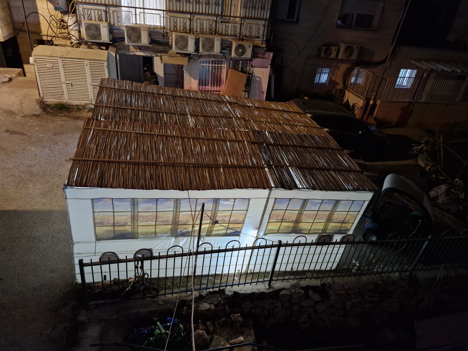 The completed sukkah viewed from outside at night
