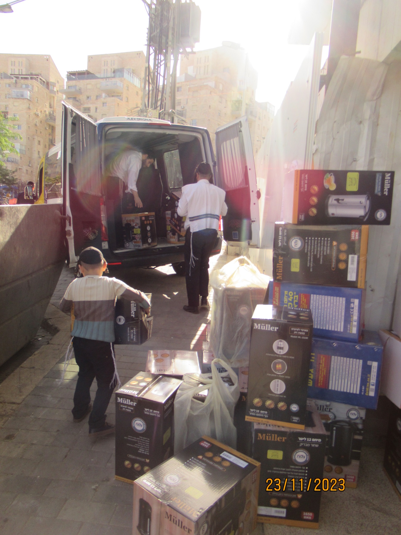 Volunteers loading boxed Shabbos equipment into a vehicle